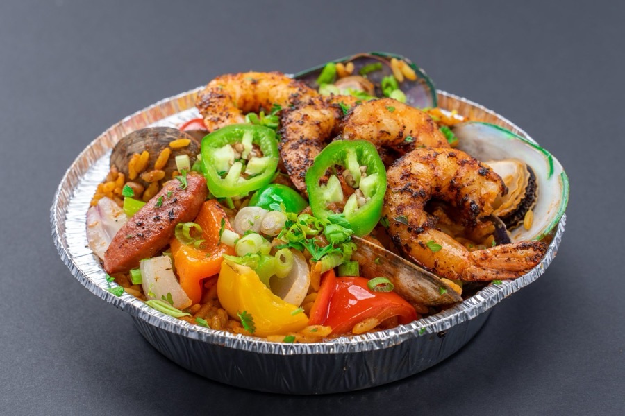 A bowl of Cajun jambalaya with shrimp, mussels, and hot links