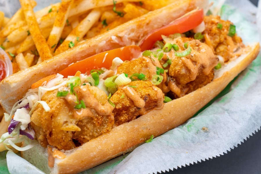 A Po' Boy sandwich on a French roll with fries on the side